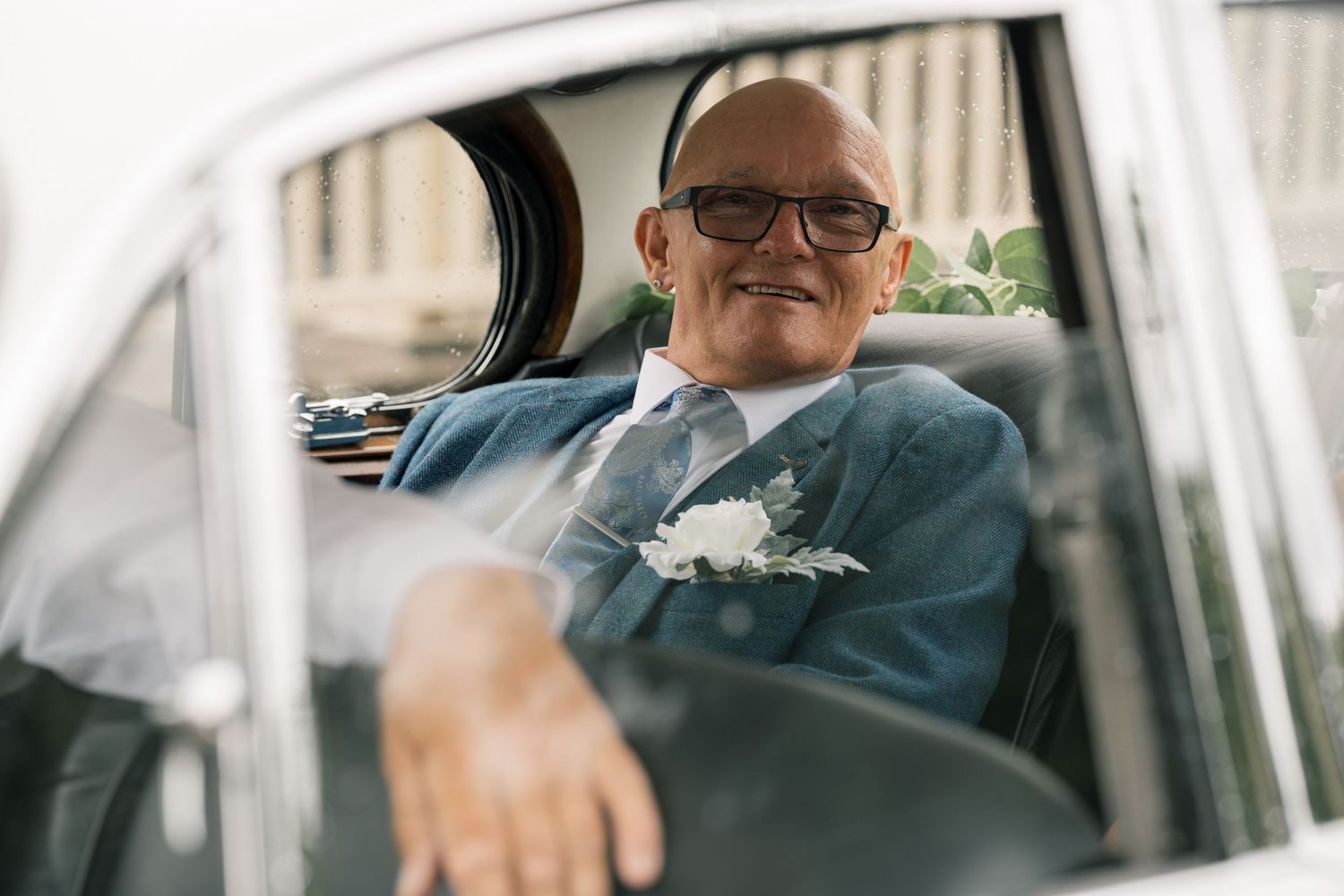 Wedding party members smiling in a car on the special day.