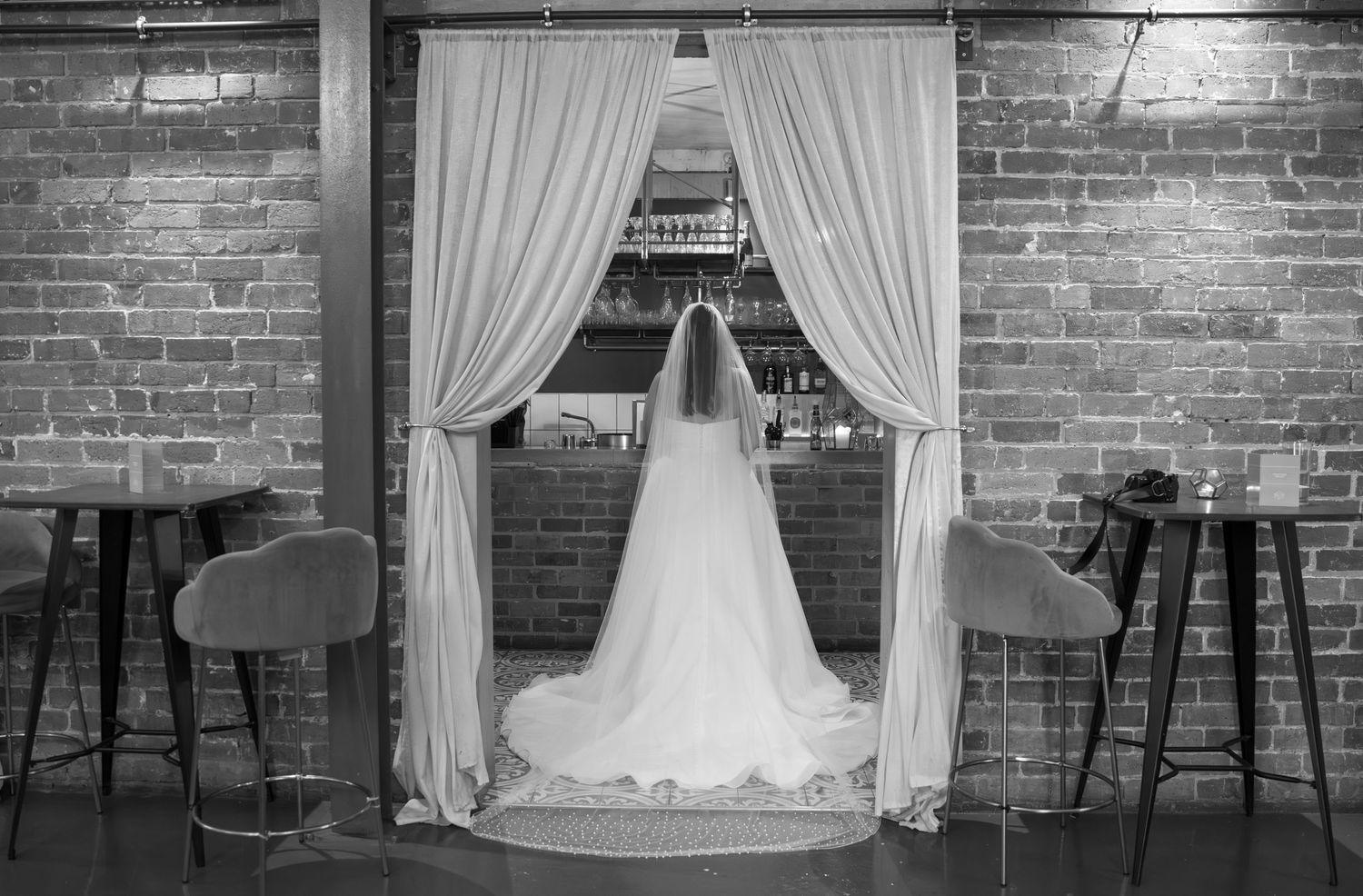 Interior shots of a rustic wedding venue with exposed brick walls and white draping.