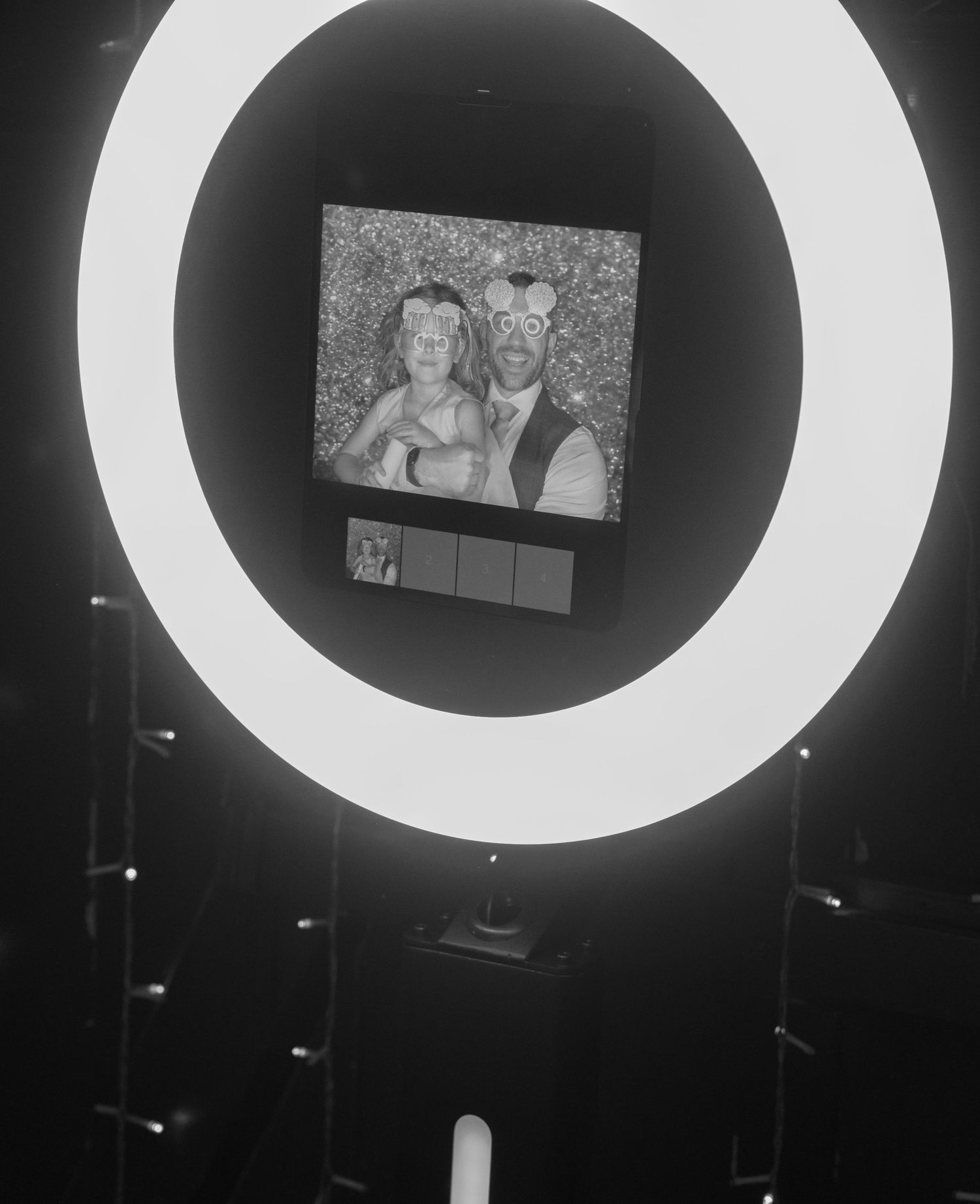 Ring light display frames wedding photos in dramatic black and white composition.