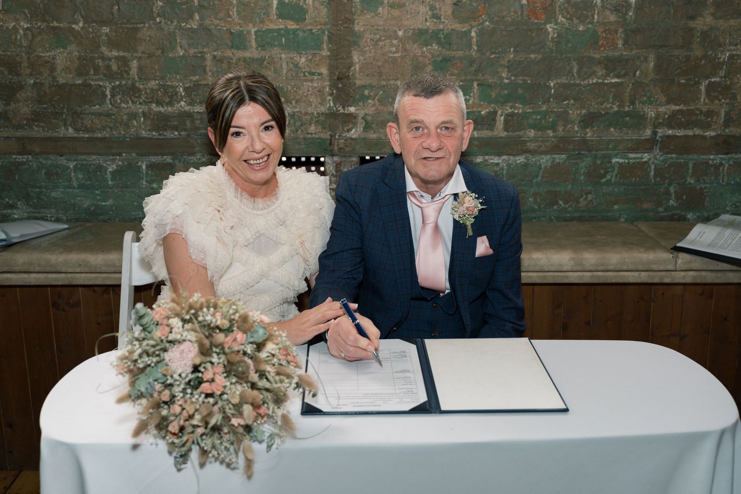 Wedding ceremony moments captured in a rustic brick venue with natural lighting.