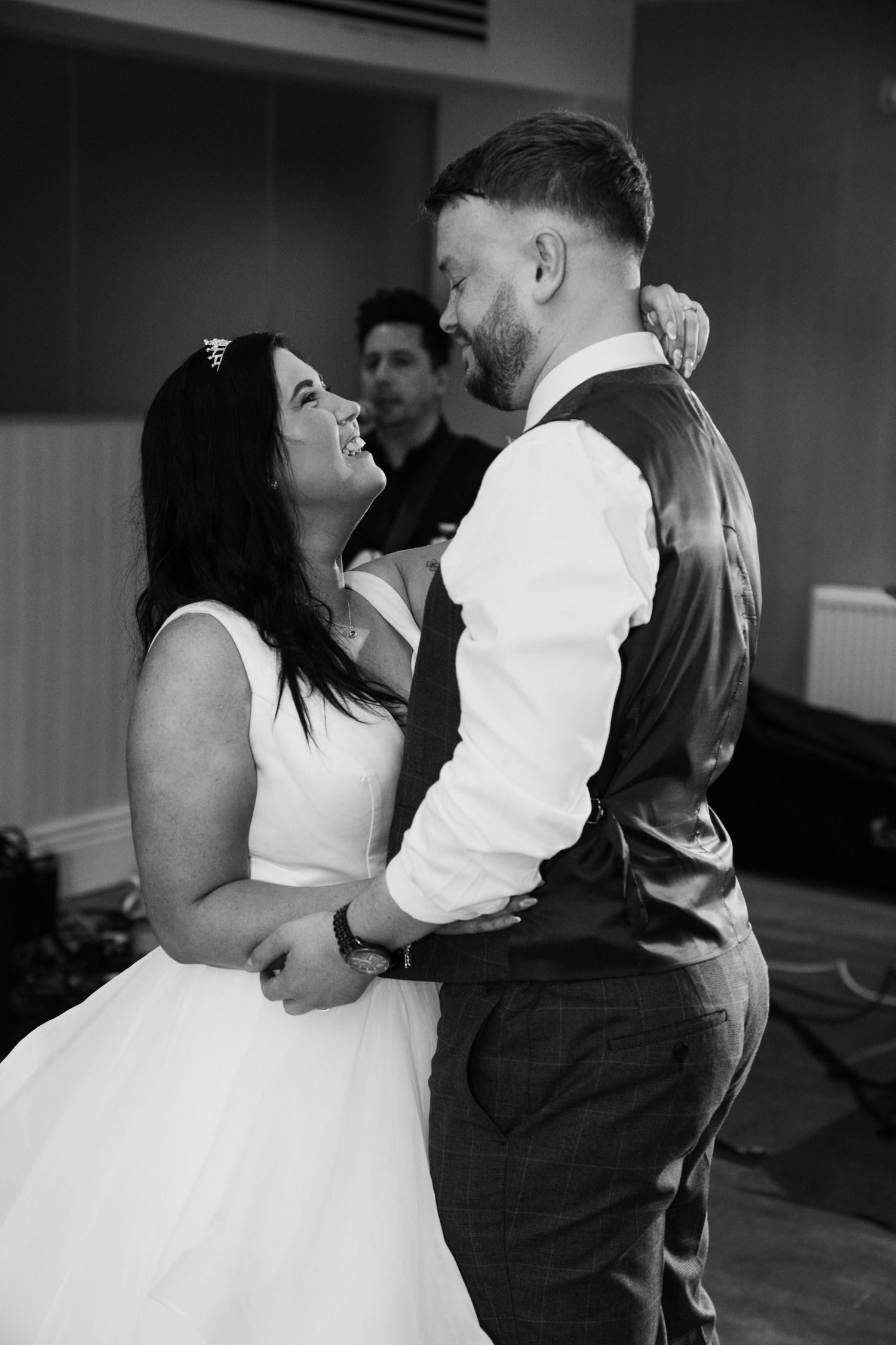 Intimate black and white wedding dance moment captured in an indoor venue.