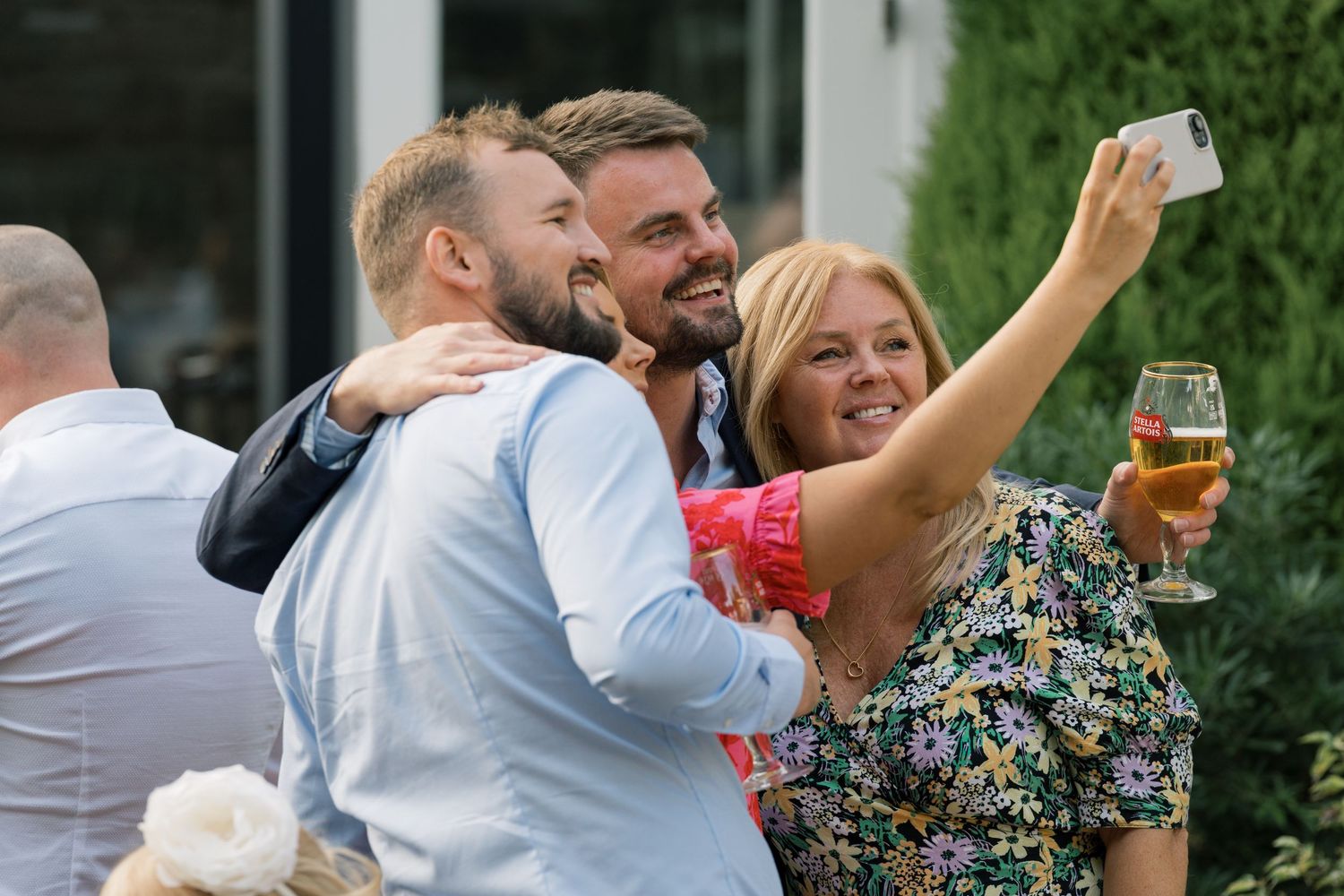 Candid party scene with guests laughing and celebrating outdoors under string lights.