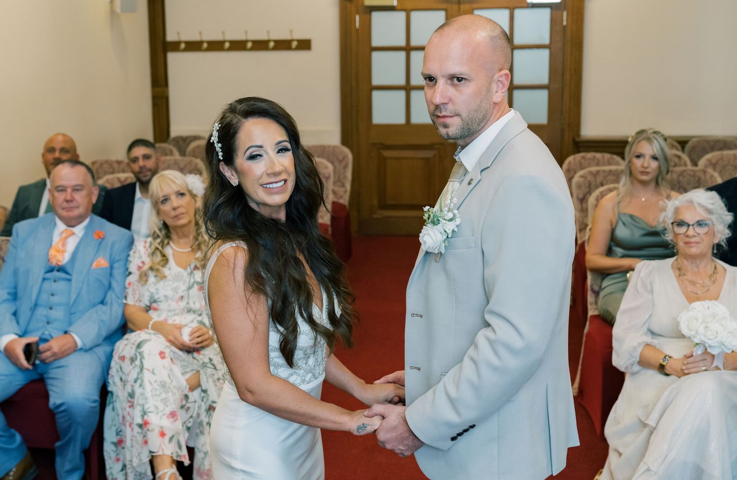 Wedding guests dance and celebrate together at a reception in a rustic venue with wooden decor and warm lighting.