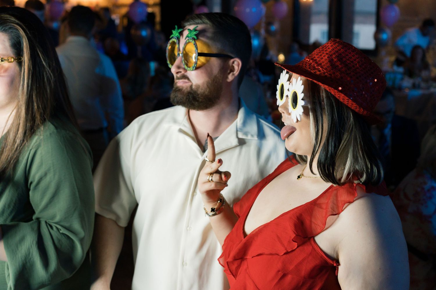 Wedding guests mingle and socialize during dimly lit evening reception.