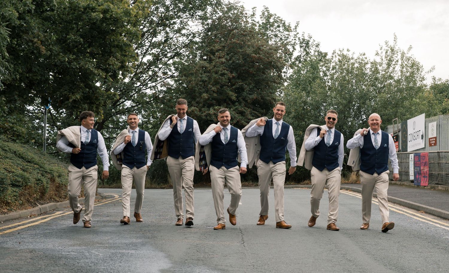 A creative wedding party photo series showing groomsmen walking in sequence with matching vests and khaki pants.