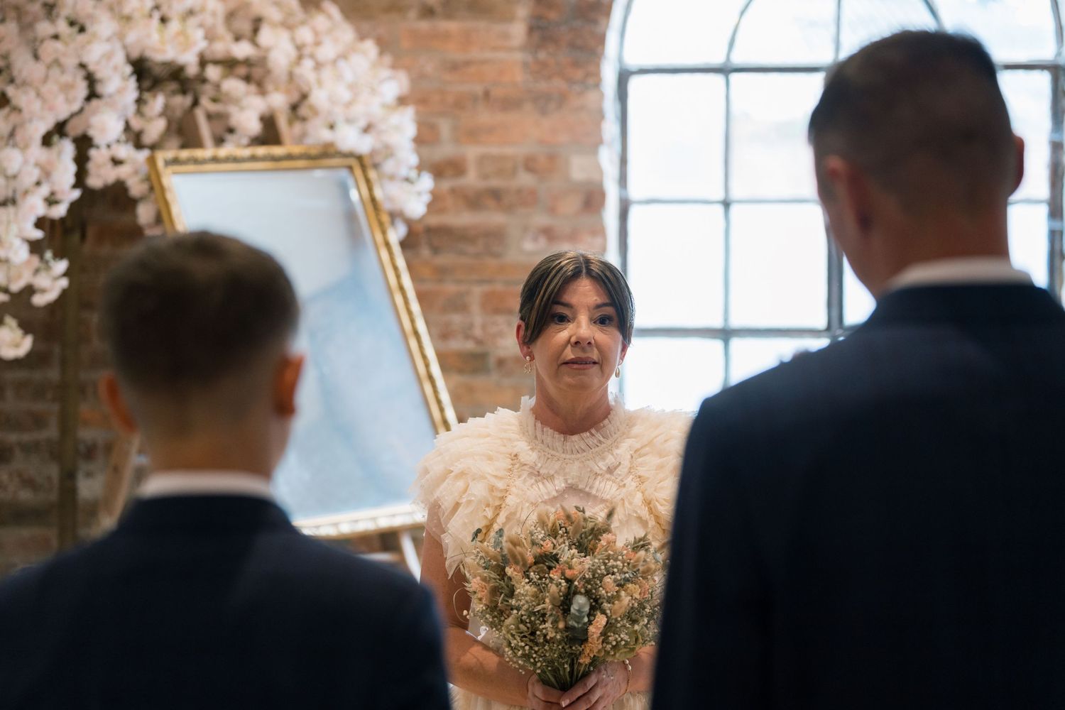 A wedding ceremony sequence showing bride and groom at the altar in a rustic brick venue with natural lighting.