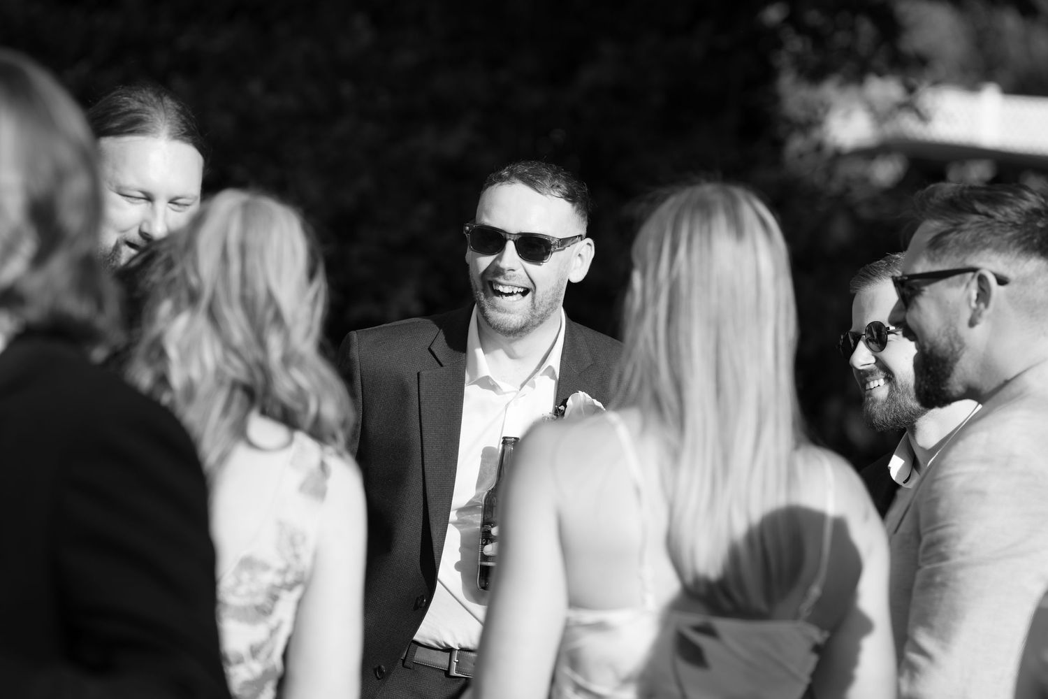 Black and white candid shots of wedding guests mingling at the reception.