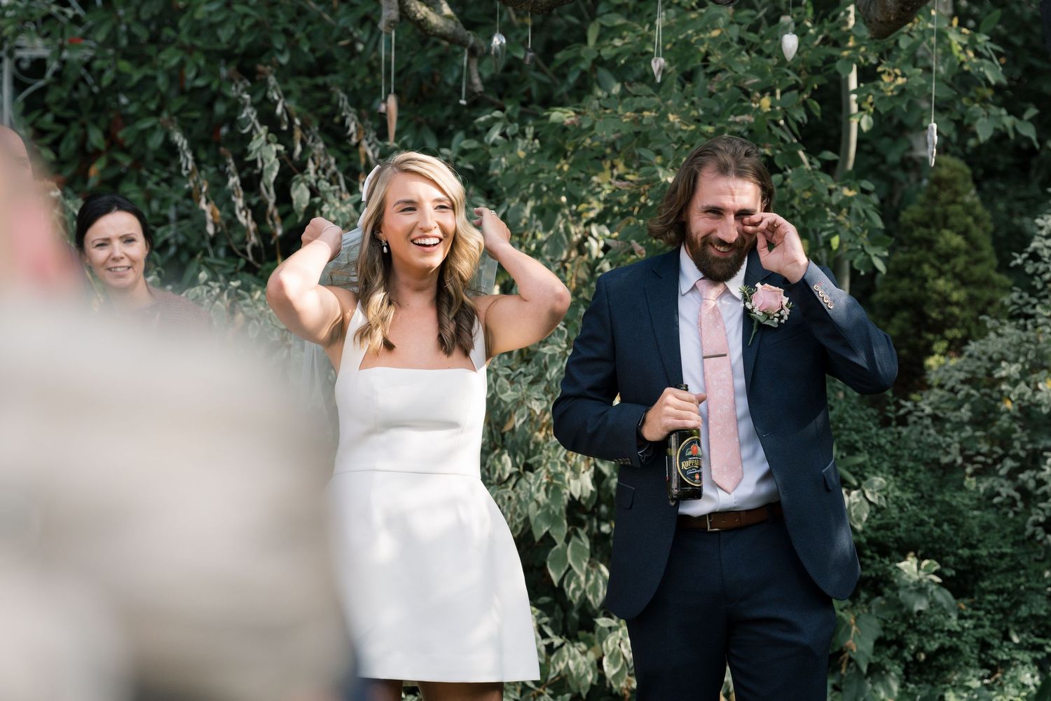 Candid moments of wedding guests mingling in an outdoor garden setting.