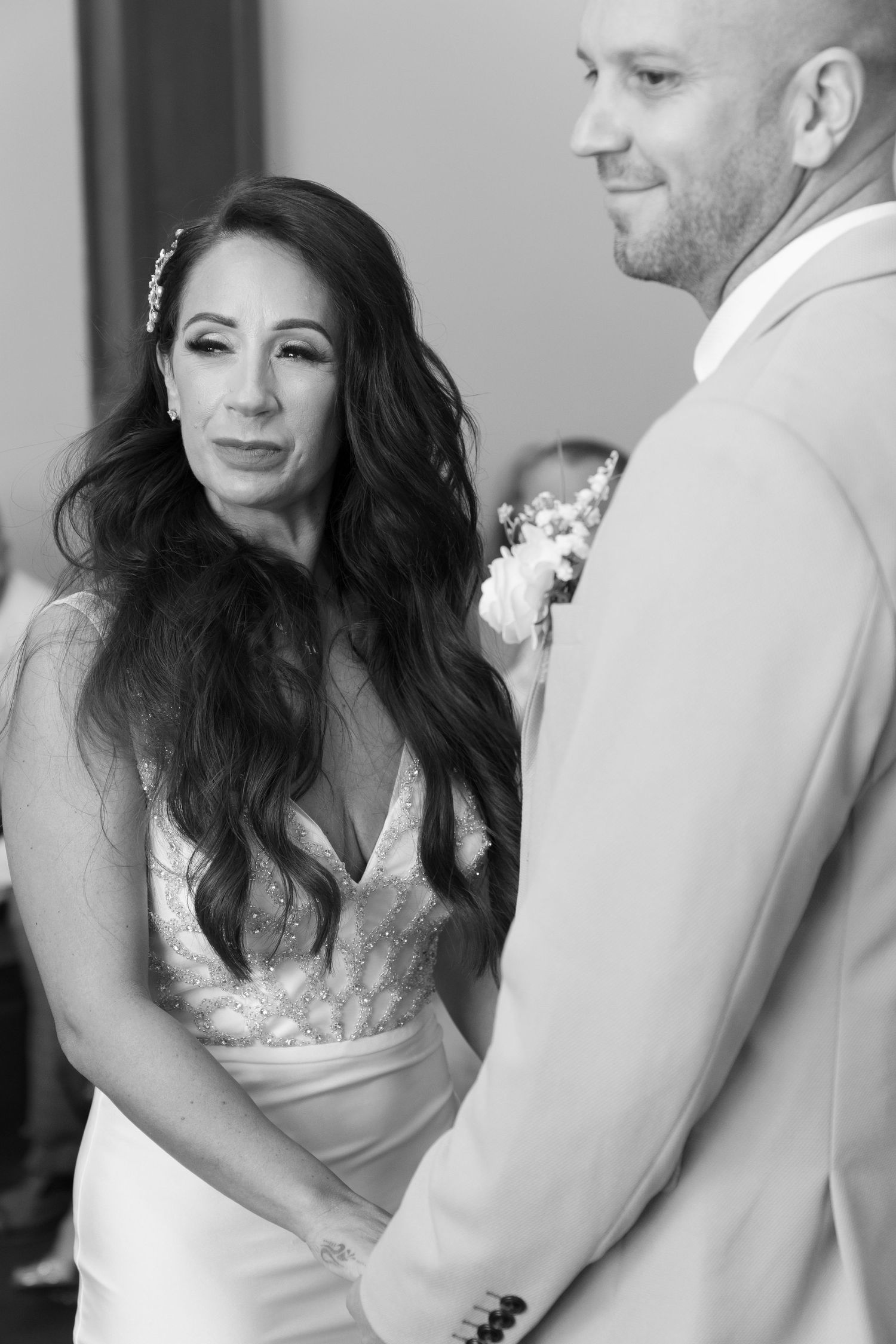 Black and white portrait of couple in wedding attire with elegant lace dress detail.