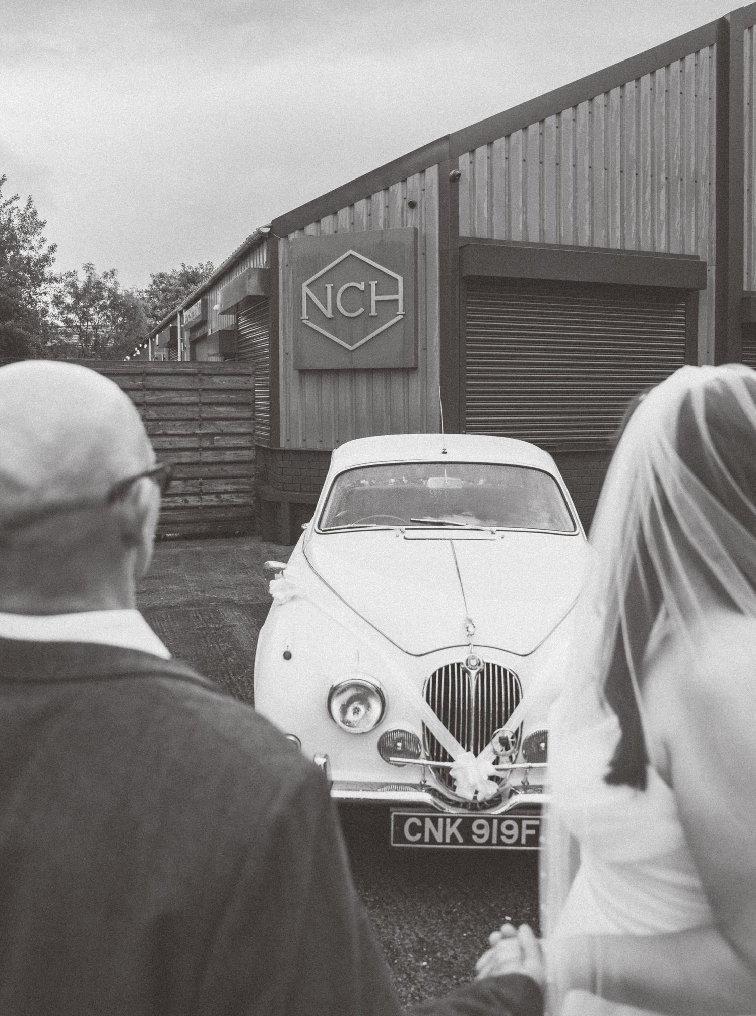 Classic vintage white car parked outside a building for a wedding photoshoot.