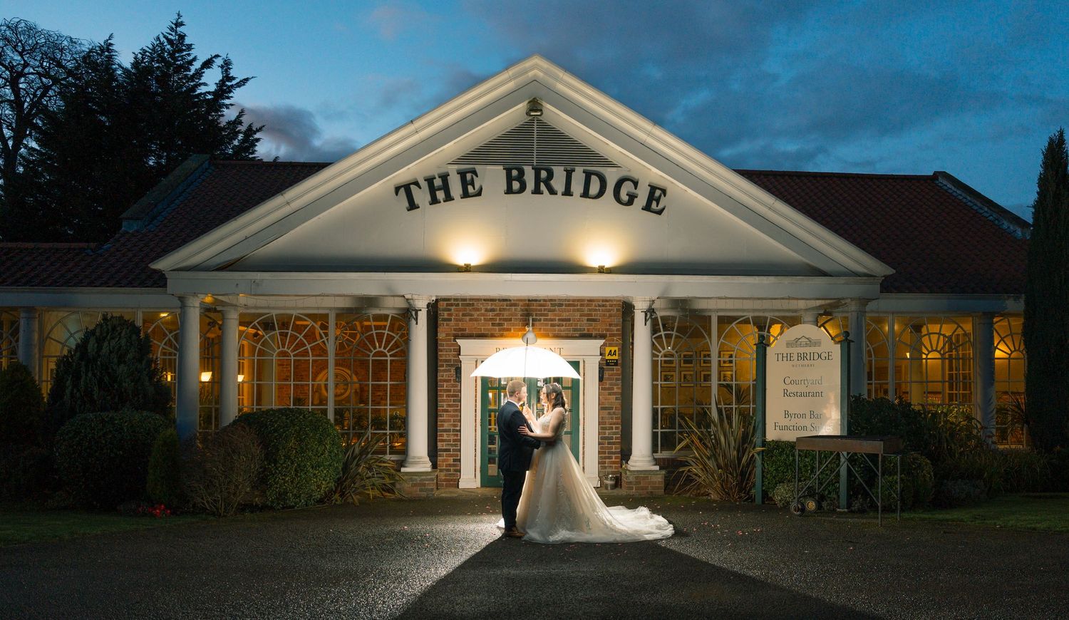 Wedding venue exterior shots at dusk showing illuminated building facades and outdoor ceremony spaces at The Bridge Hotel & SPA, Selby