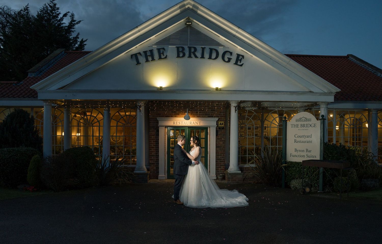 Wedding couple at The Bridge Hotel & SPA, Selby illuminated at dusk with multiple exterior shots showing elegant white architecture