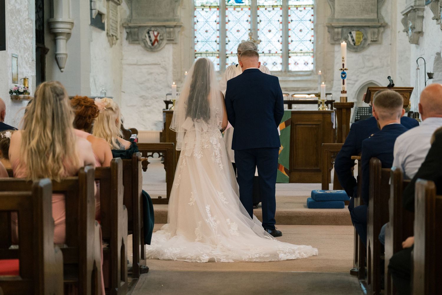A bride in a white wedding dress stands in a church aisle during a traditional wedding ceremony held at Kippax, Leeds.