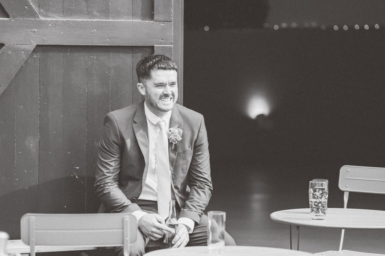 Black and white photo of a well-dressed man at an indoor event venue.