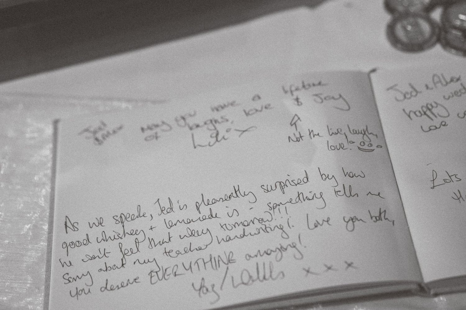 Close-up of handwritten wedding guest book messages on white paper.