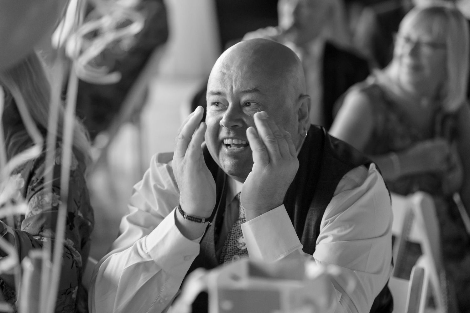 Black and white candid shots capture joyful reactions during wedding reception.