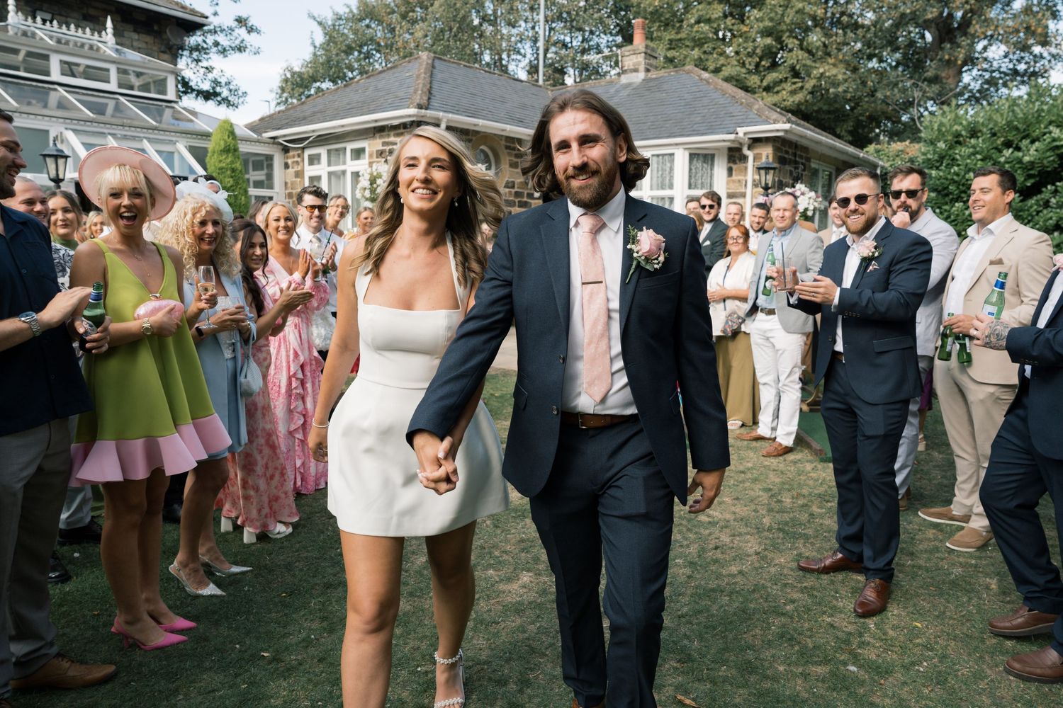 Wedding guests gathered on a sunny lawn during an outdoor celebration.