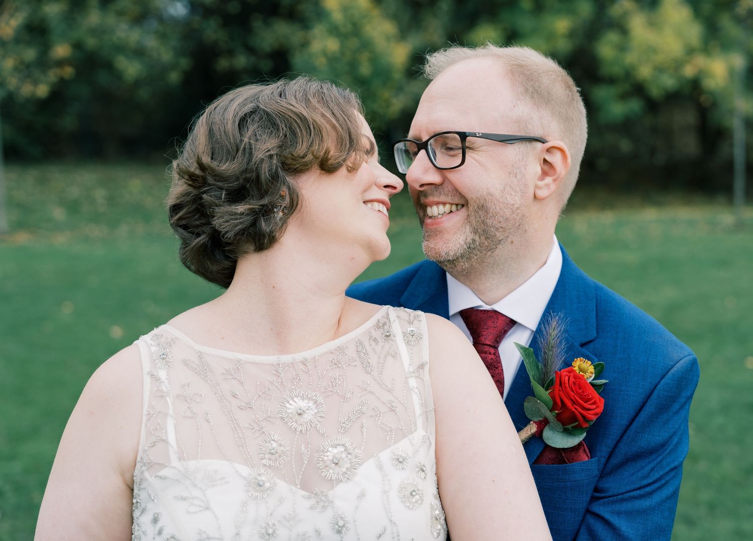 Intimate moment between wedding couple outdoors with natural garden background.