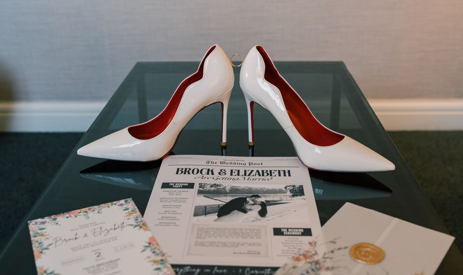 A display of white Christian Louboutin high heel shoes with red soles arranged in a row on a shelf.