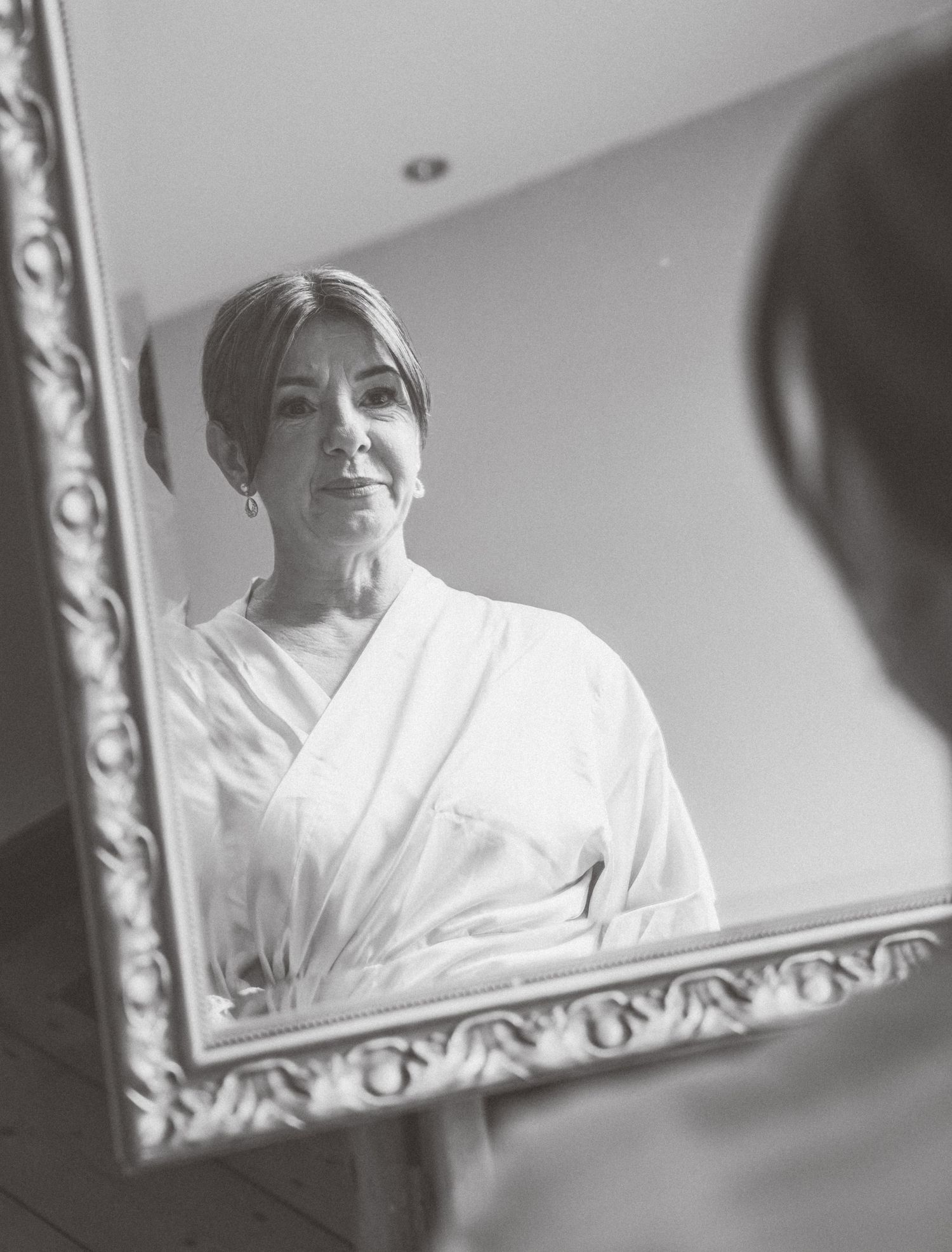 A series of black and white photos showing someone in a white robe looking up at a decorative mirror.