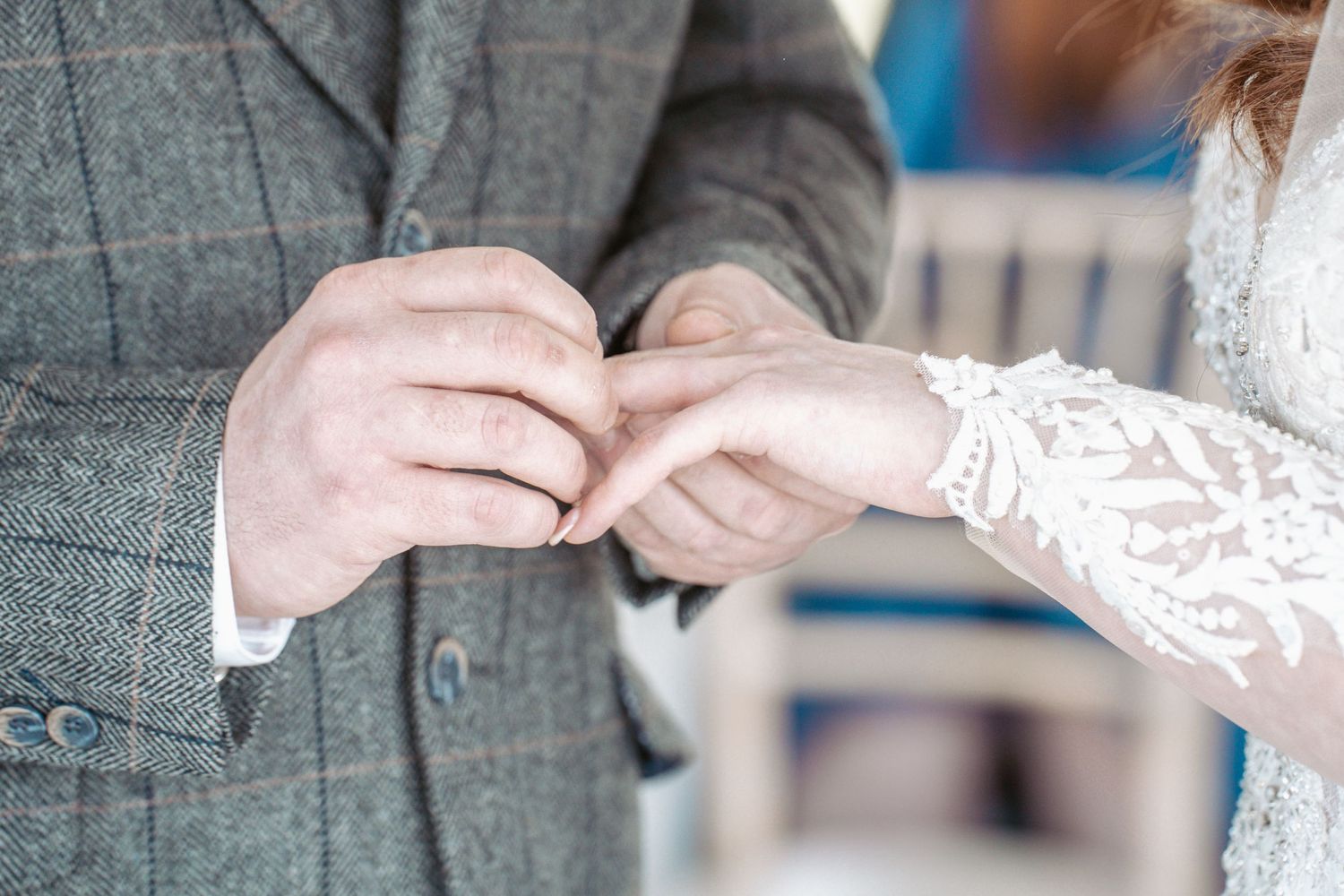 Close-up shot of hands exchanging rings during a wedding ceremony.