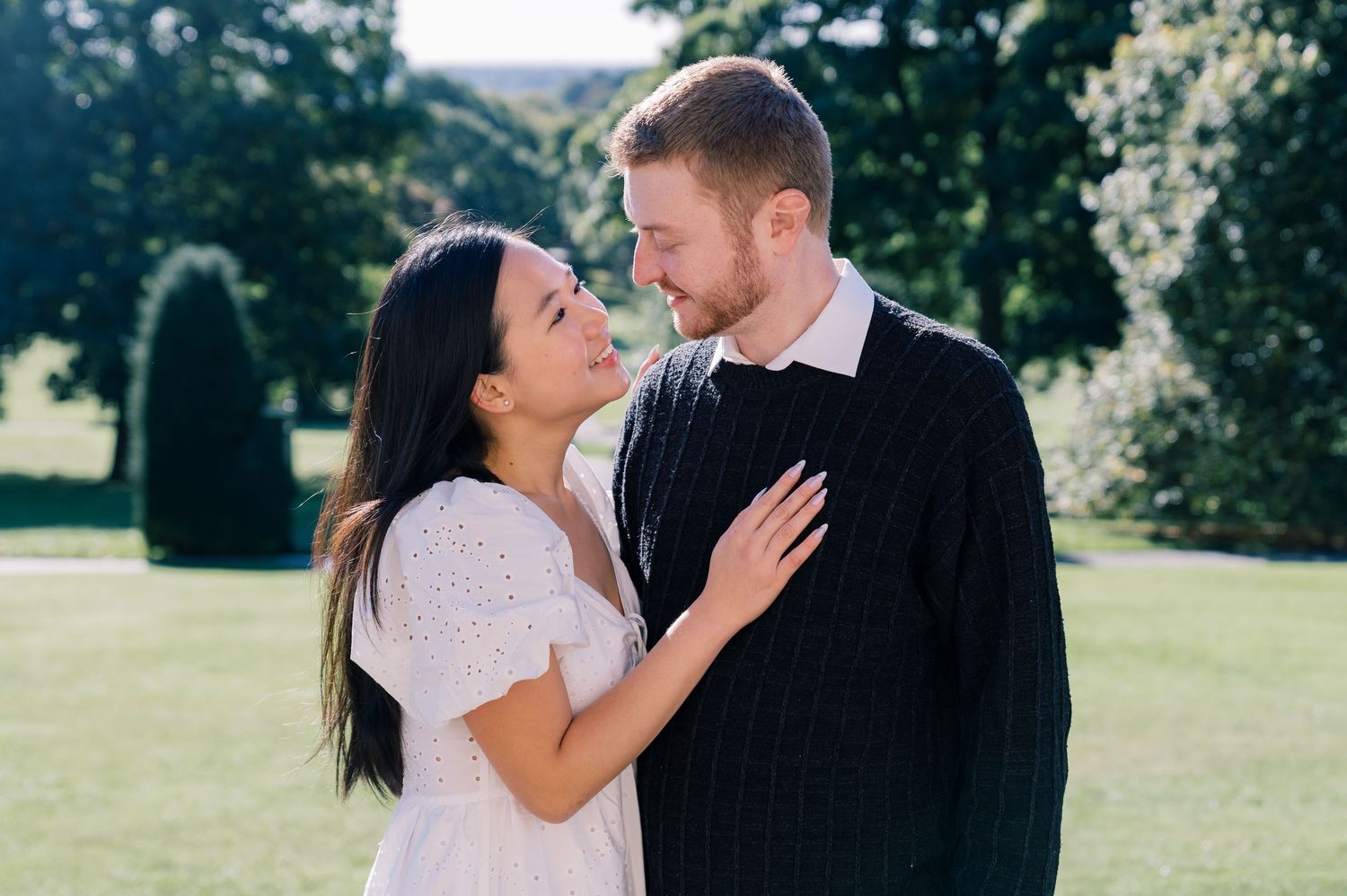 An intimate moment captured between a couple in a garden setting.