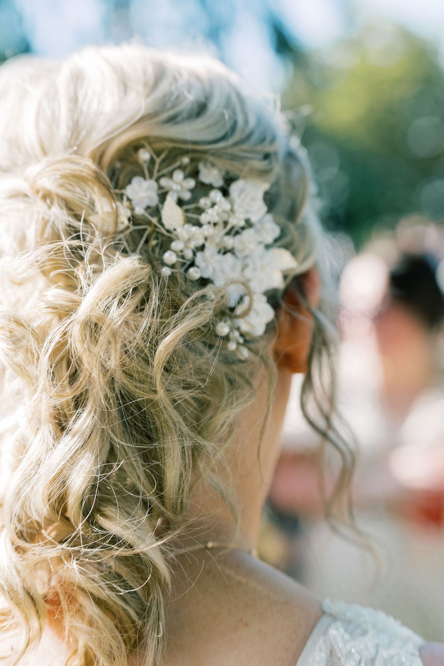 Elegant bridal hairstyle with delicate white flowers woven into blonde curls.