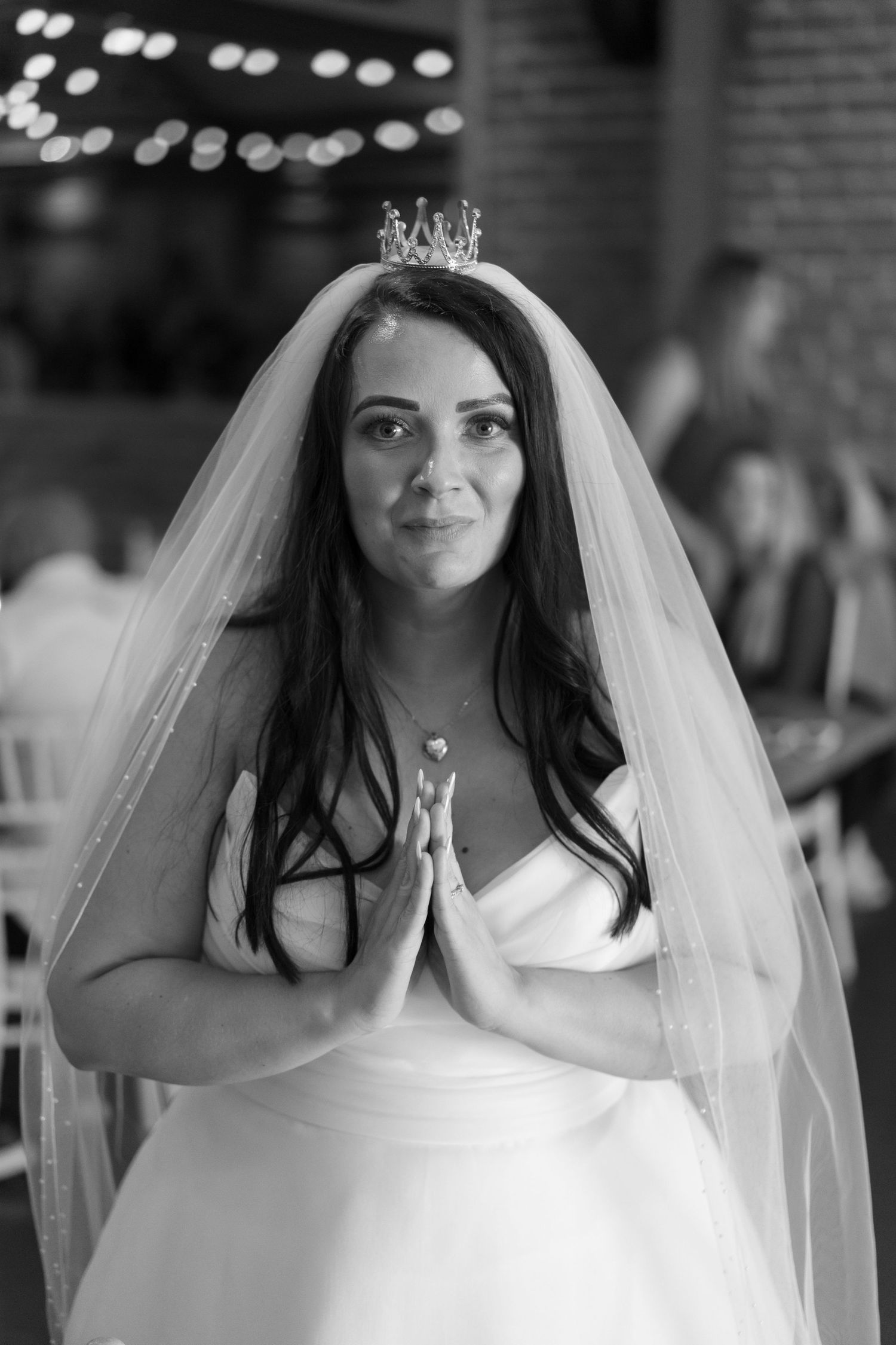 Bride in white dress and veil poses during wedding celebration.