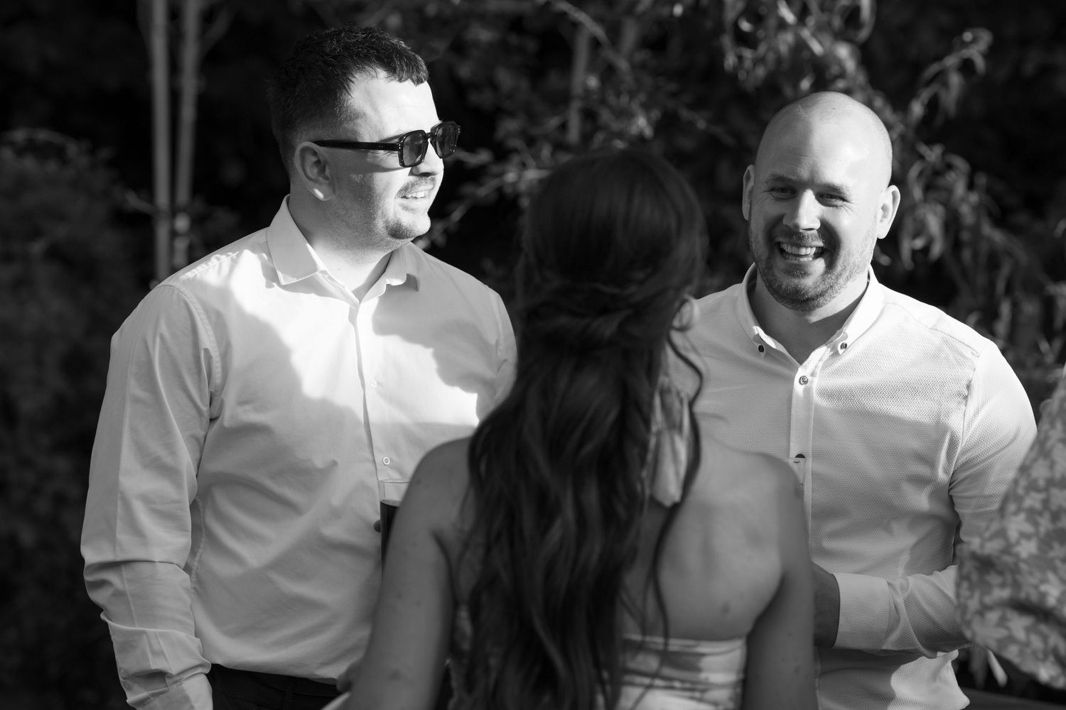 Wedding guests in casual attire enjoying outdoor celebration.