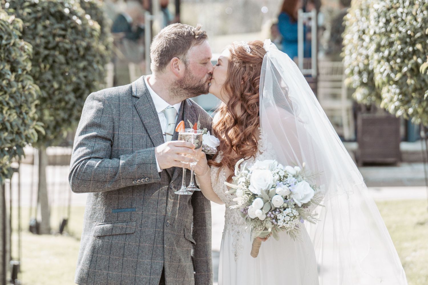 A romantic outdoor wedding moment with a couple sharing a toast.