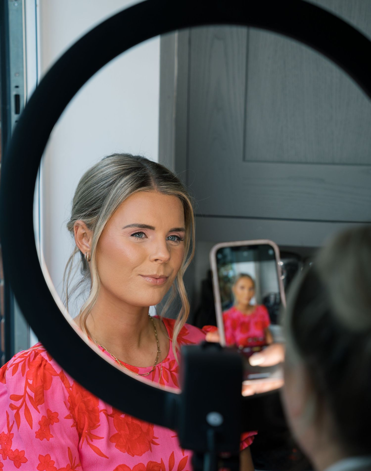 A sequence of mirror reflections showing someone in a bright pink top getting ready.