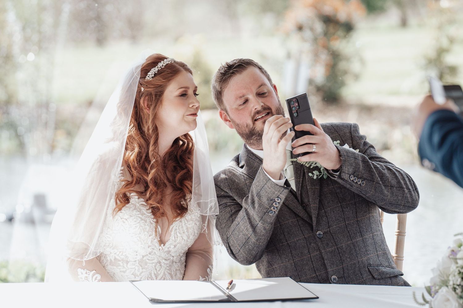 A couple sharing a lighthearted moment while signing their wedding documents.