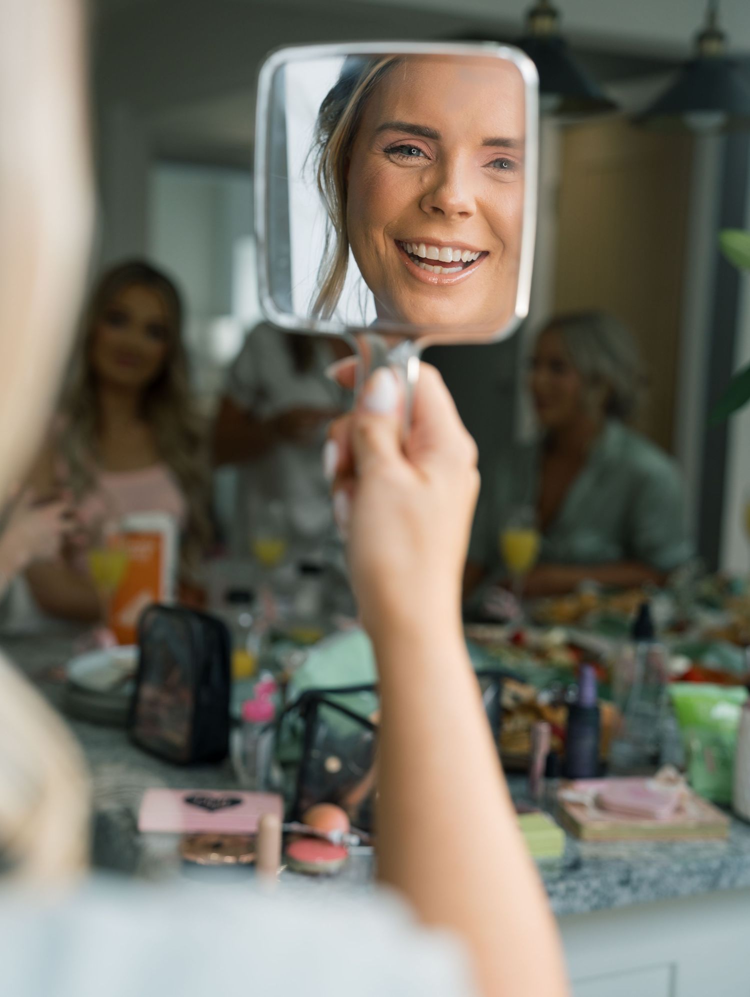 Bridal party getting ready together with makeup and beauty preparations in a bright indoor setting.