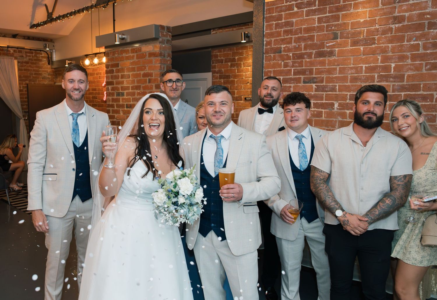 Wedding party celebrating in industrial venue with exposed brick walls.