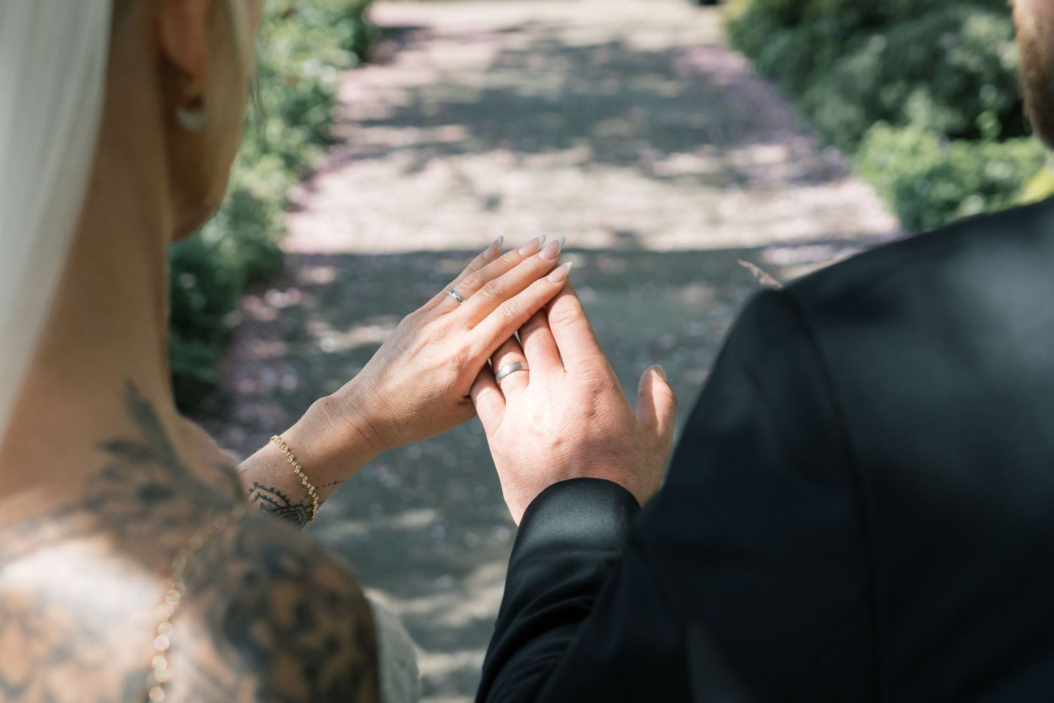 Close-up of bride and groom holding hands, showcasing a diamond wedding ring on their wedding day, which took place in Leeds.