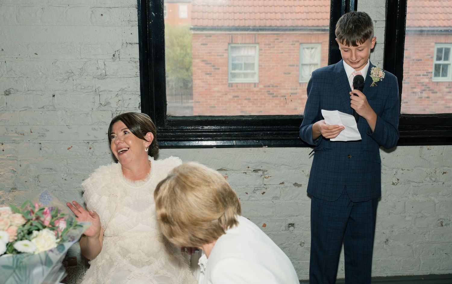 Wedding celebration candid moments in industrial brick venue.