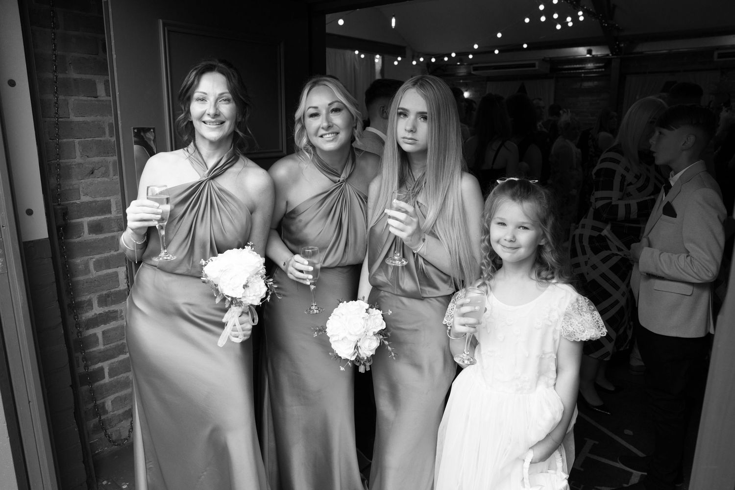 Wedding party members in formal attire pose together in a series of black and white photographs.