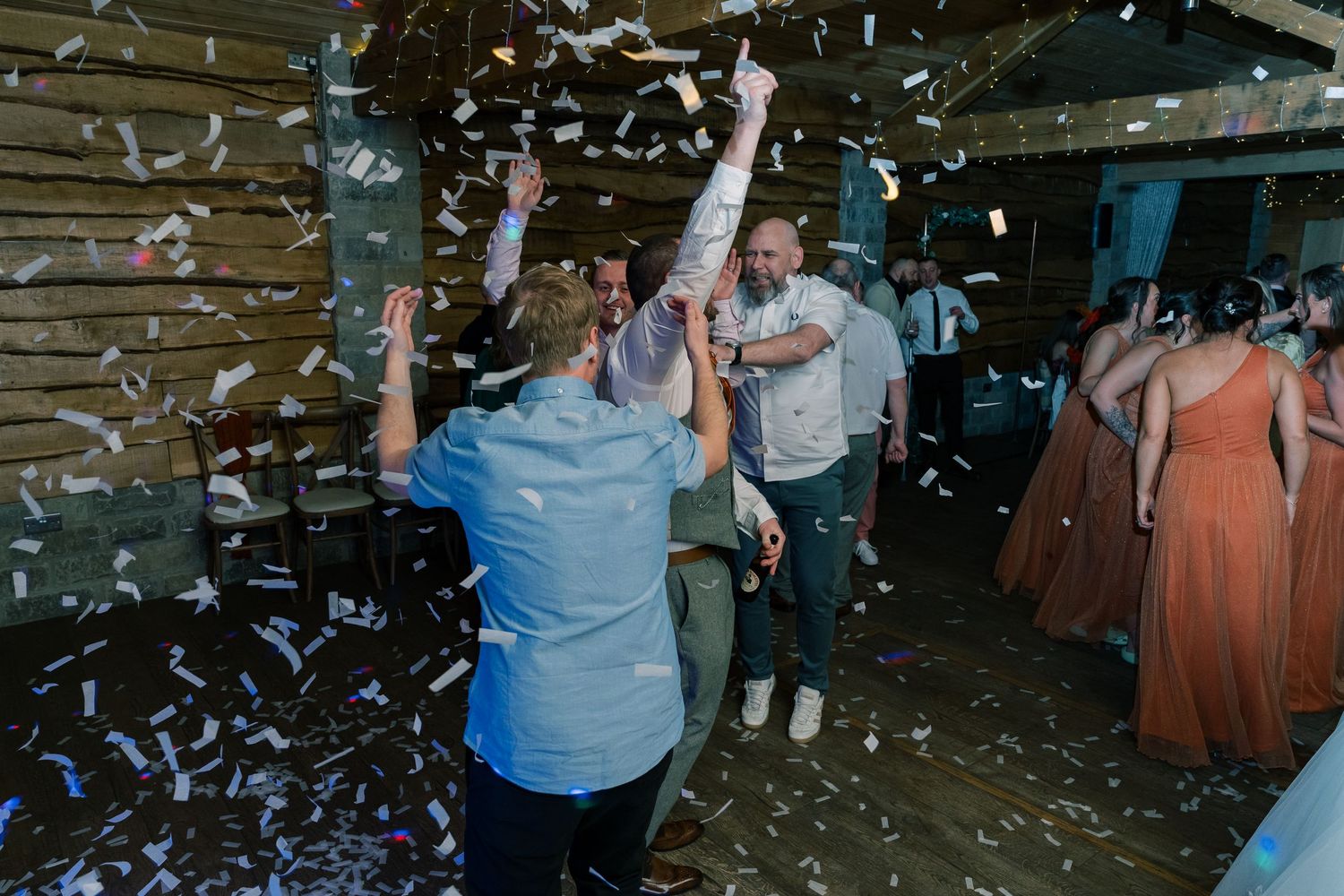 People dancing and celebrating at a wedding reception while confetti falls from above, at Spicer Manor, Sheffield.