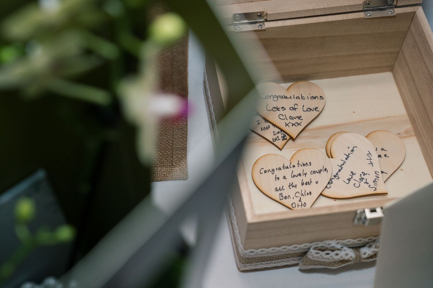 Wooden wedding guest book pages with handwritten messages and signatures from attendees.