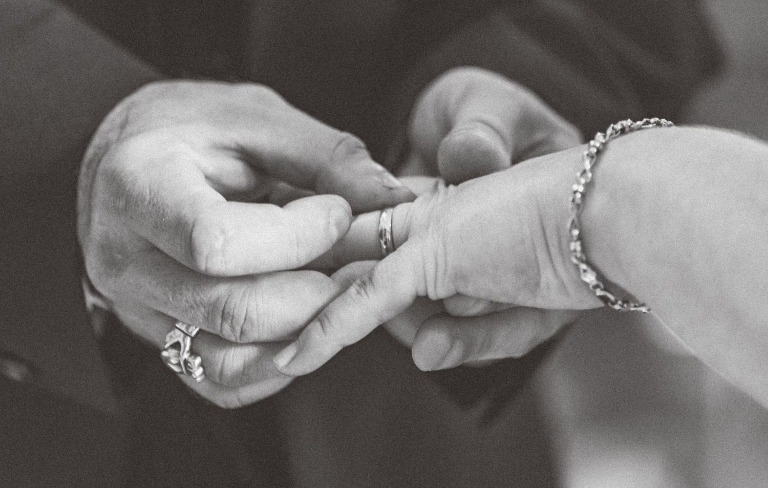 Black and white close-up sequence showing hands exchanging rings during a wedding ceremony at Leeds Civic Hall.