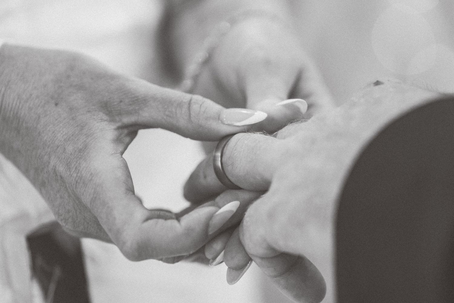 Black and white photo of a couple exchanging wedding rings during a marriage ceremony in Leeds.
