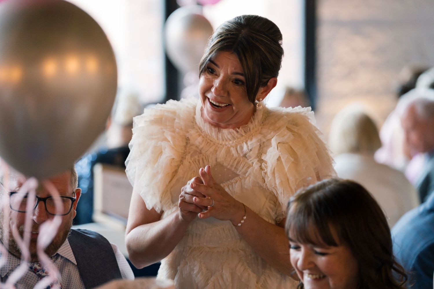 Wedding celebration with person in feathered dress laughing during reception.