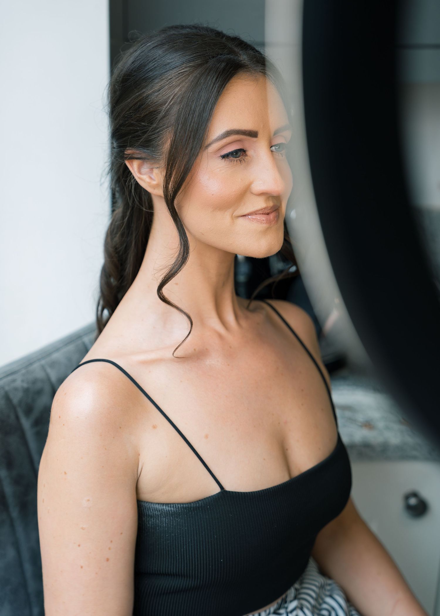 Sequence of photos showing woman in black tank top posing against dark background.