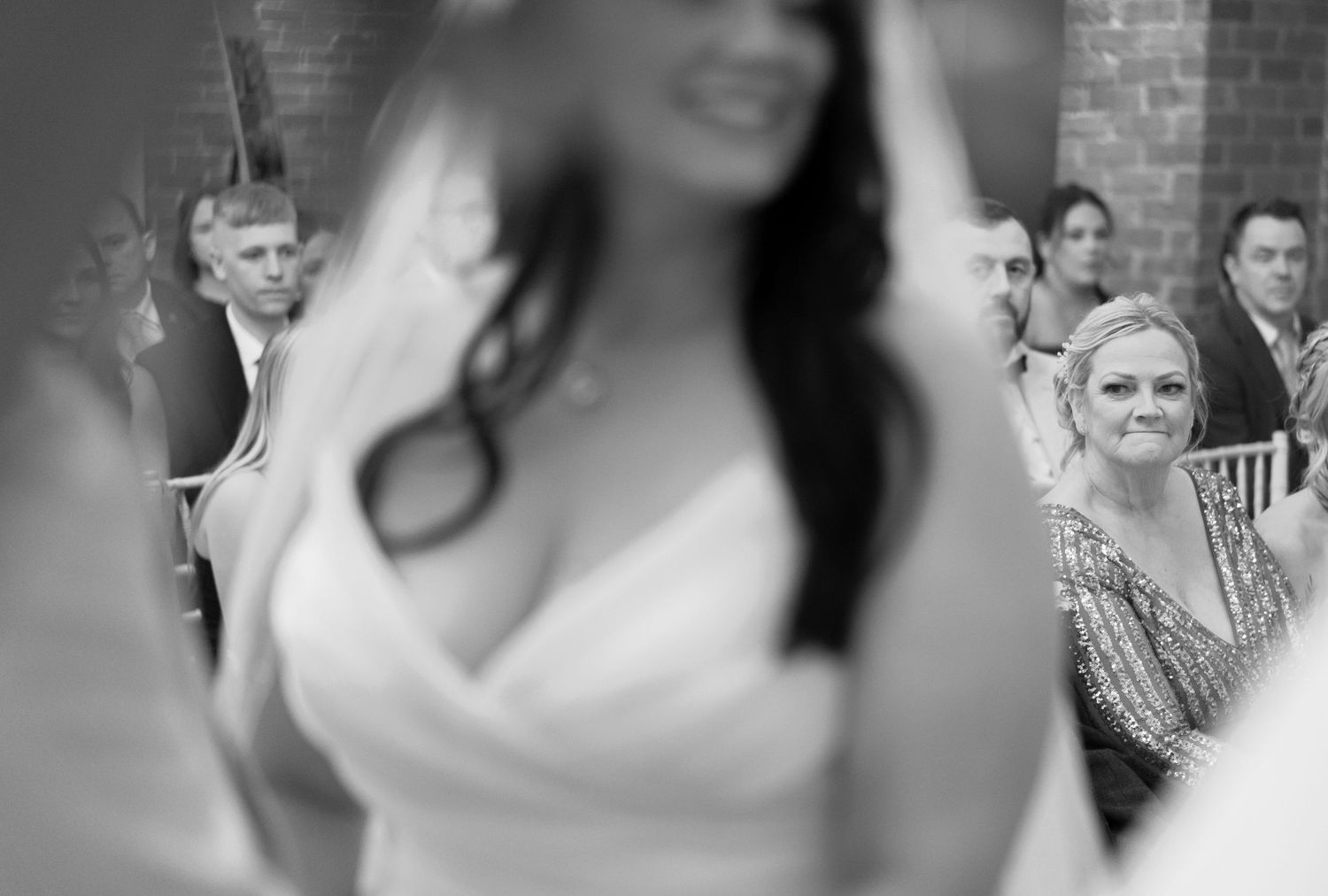 Black and white candid shots of wedding guests enjoying the celebration.