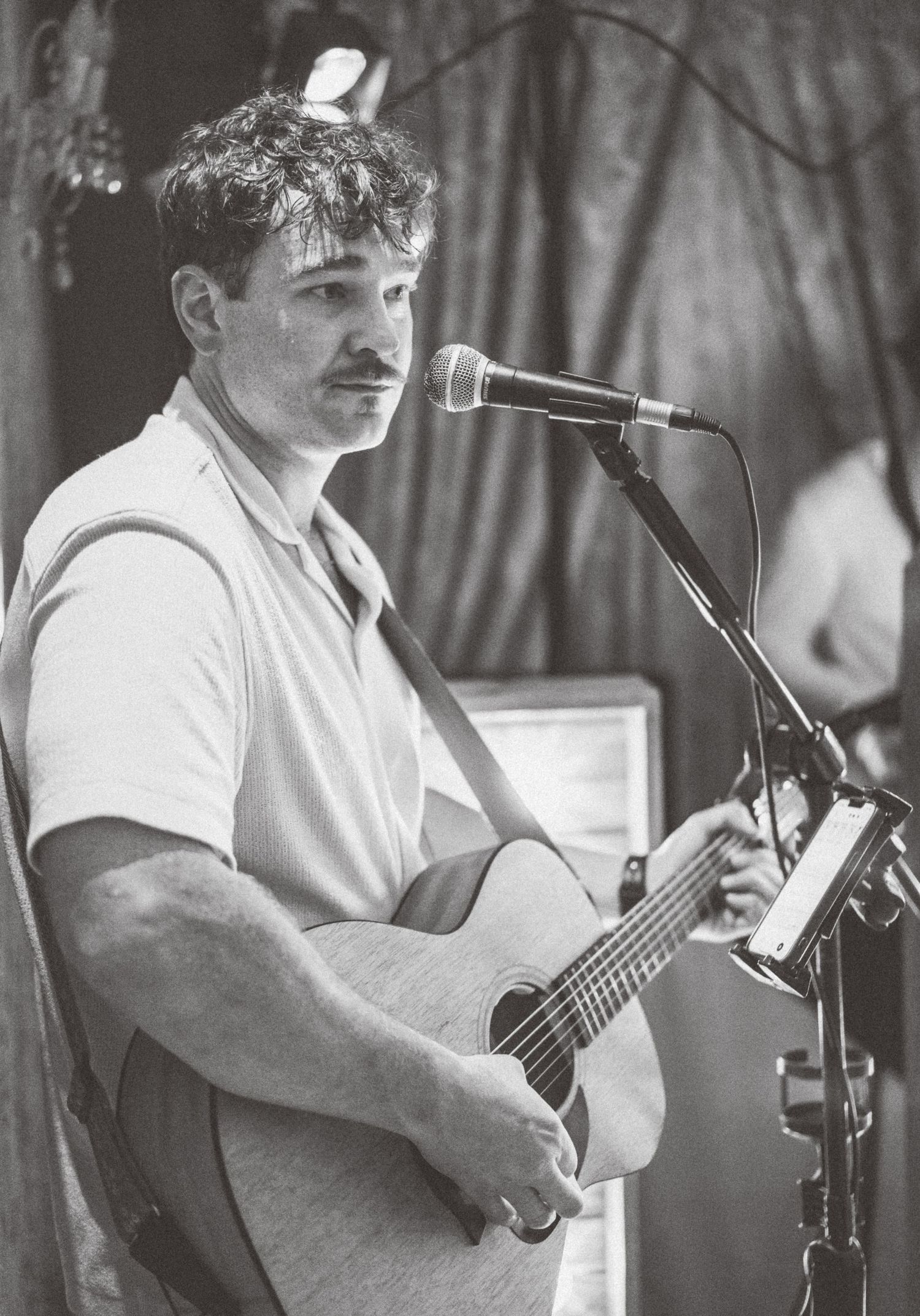 Black and white images of musicians playing acoustic guitars at an event.