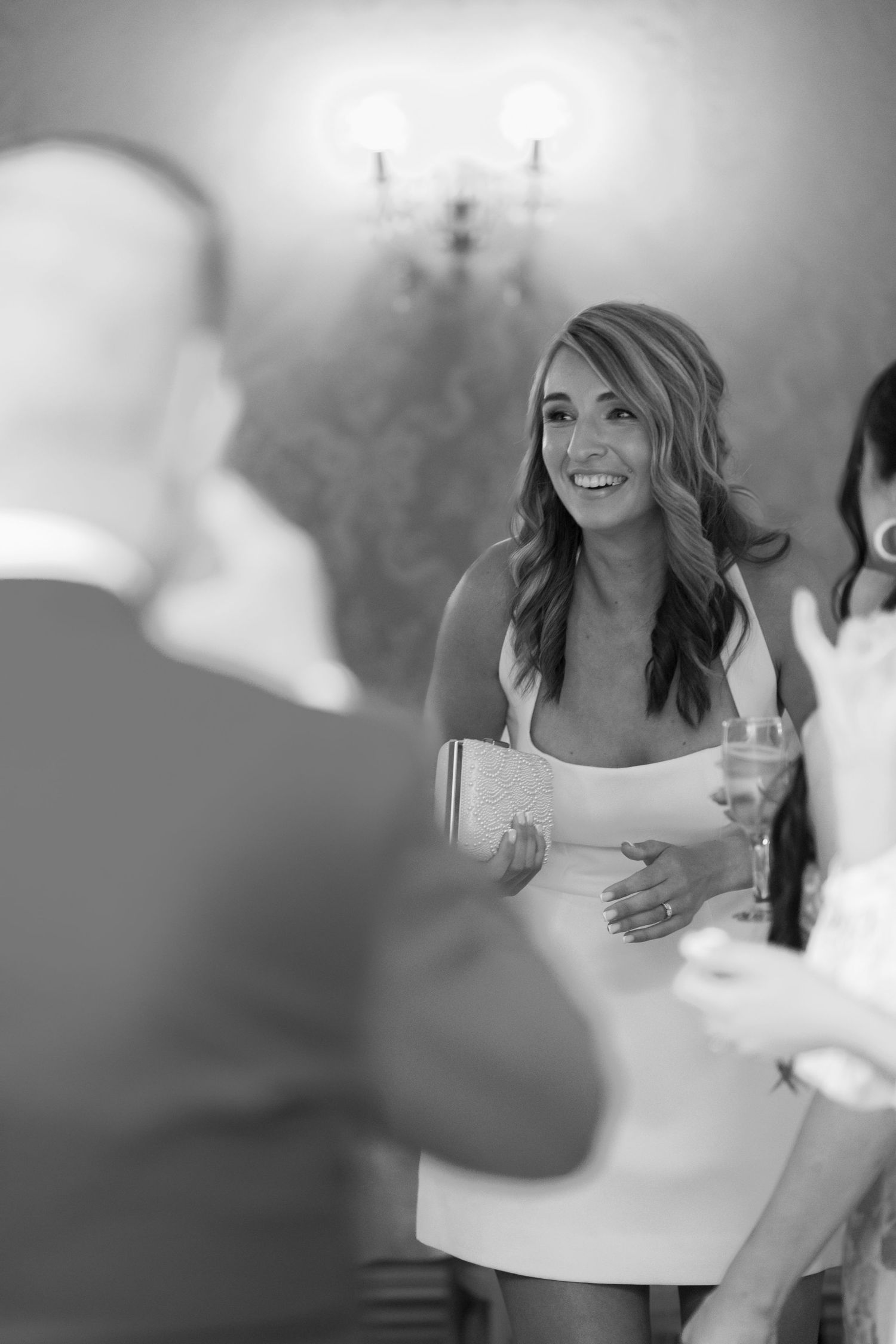 Black and white wedding photos show candid laughter and joyful moments during a celebration.