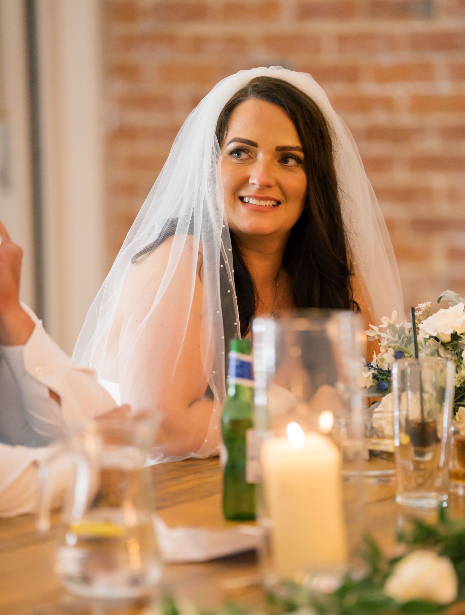 Wedding reception table setting with candlelight and decorative elements.