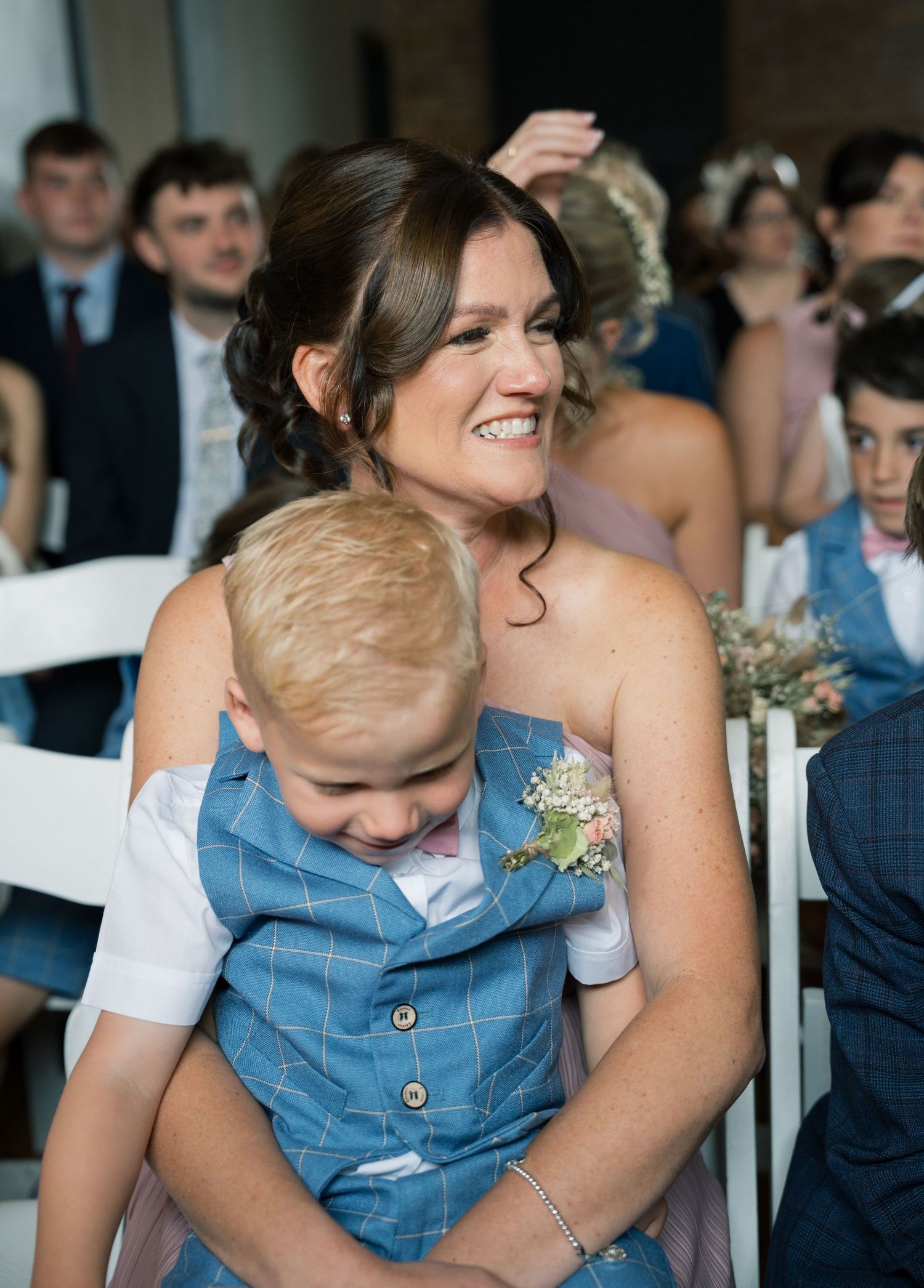 Candid moment during wedding ceremony with guest in denim outfit.