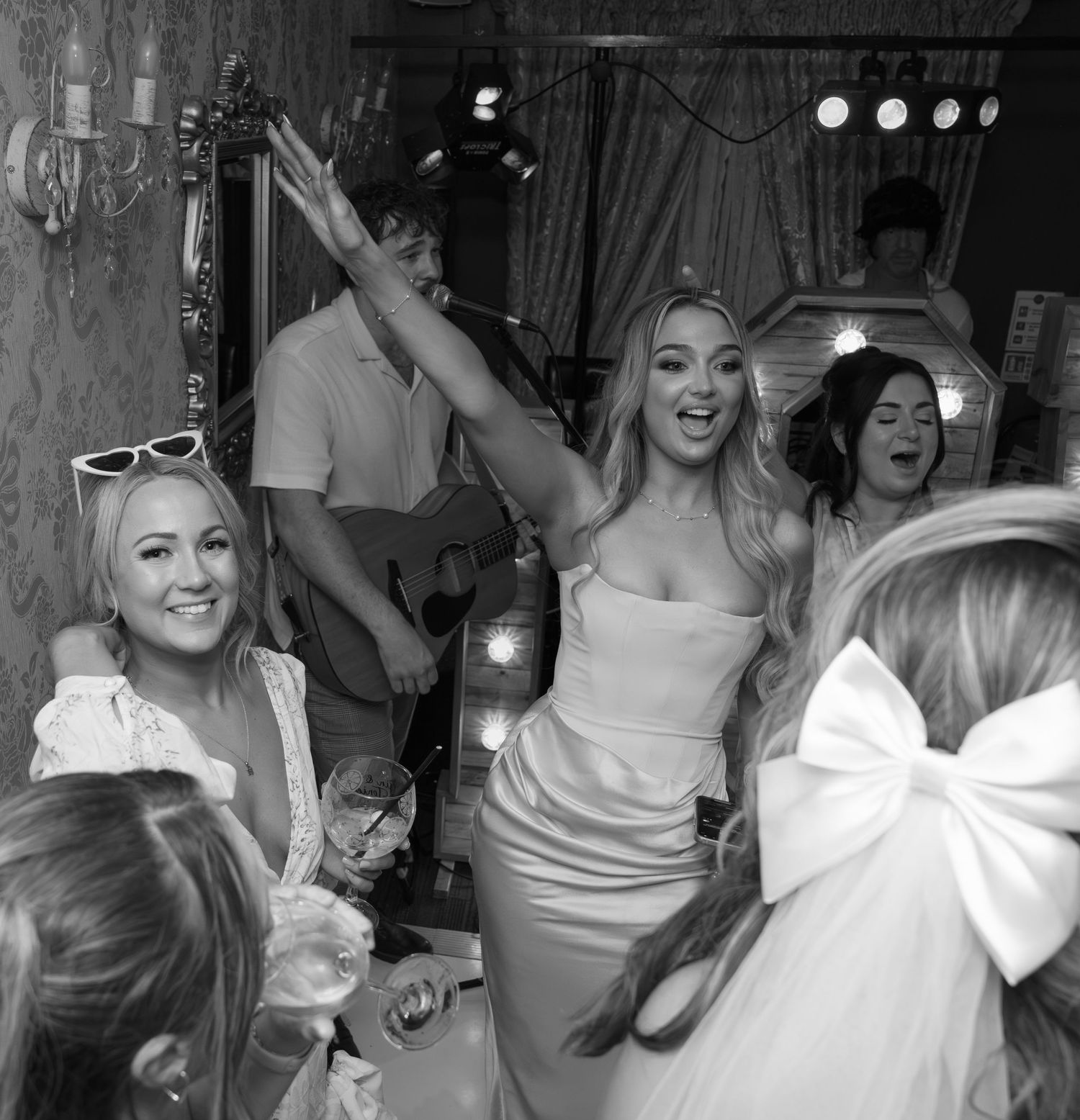 Black and white photo of wedding guests dancing and celebrating.