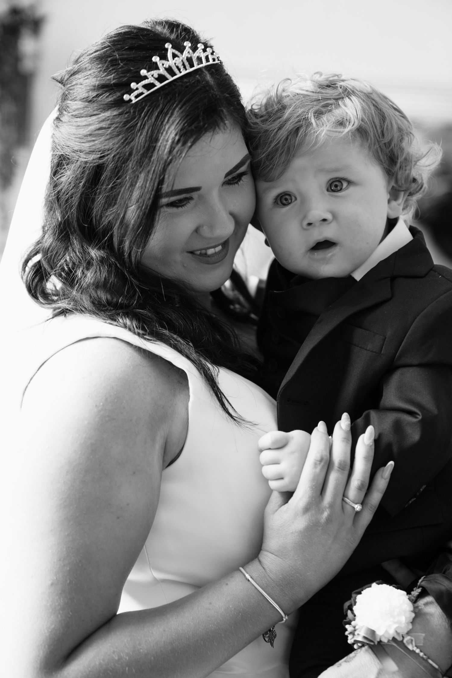 Sweet black and white wedding day portrait with small child in formal attire.